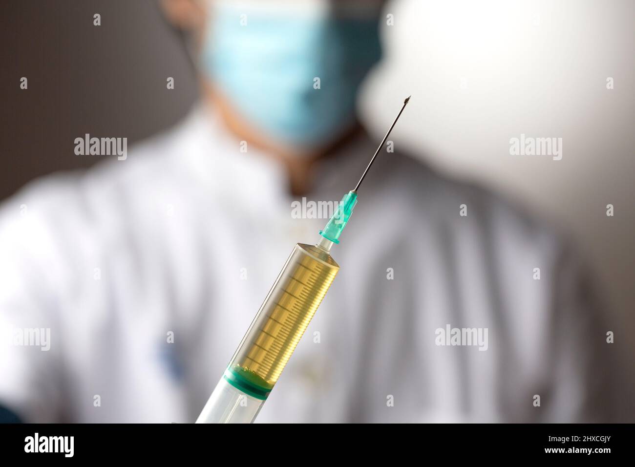 Un infermiere che tiene una siringa. Foto Stock