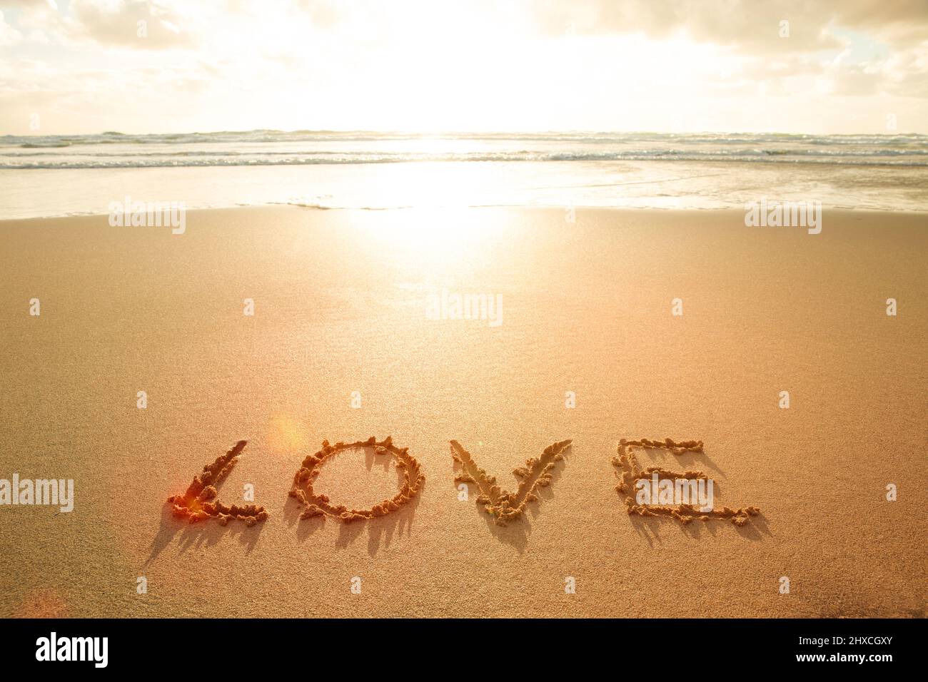 La parola amore scritte sulla sabbia Foto Stock