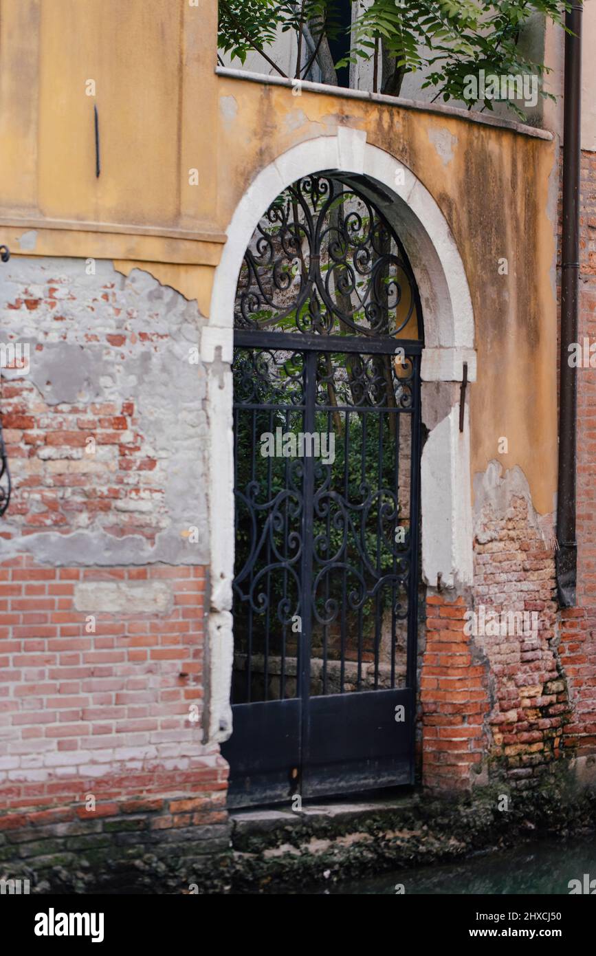 Porta ad arco barrata direttamente sul canale nel centro storico di Venezia Foto Stock