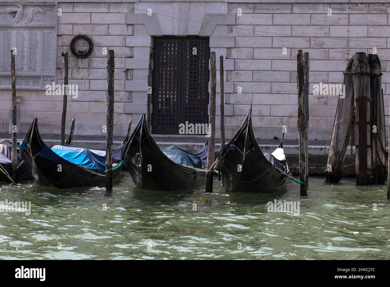 Tre gondole su pali di legno a Venezia Foto Stock