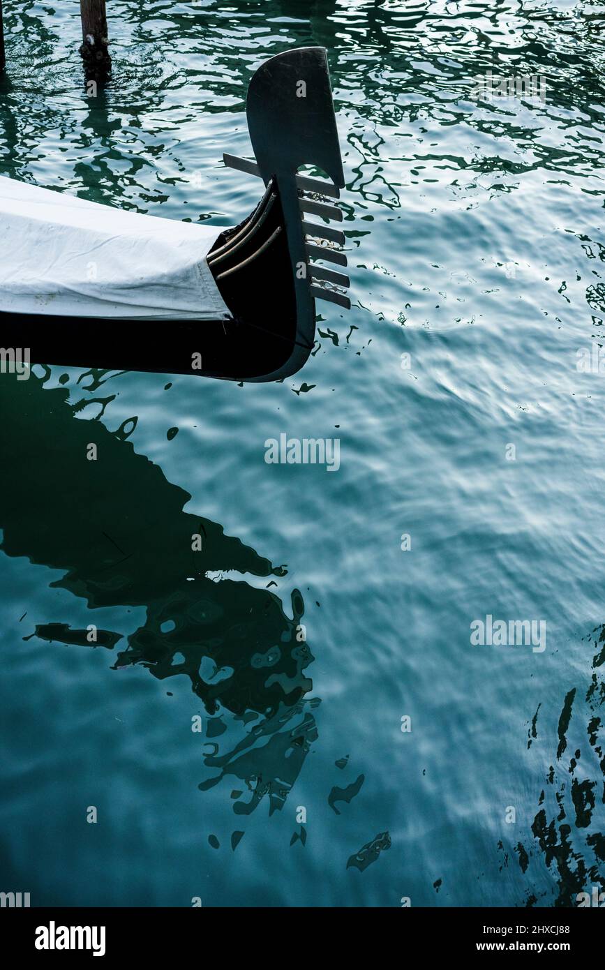 Arco di una gondola veneziana in acqua Foto Stock