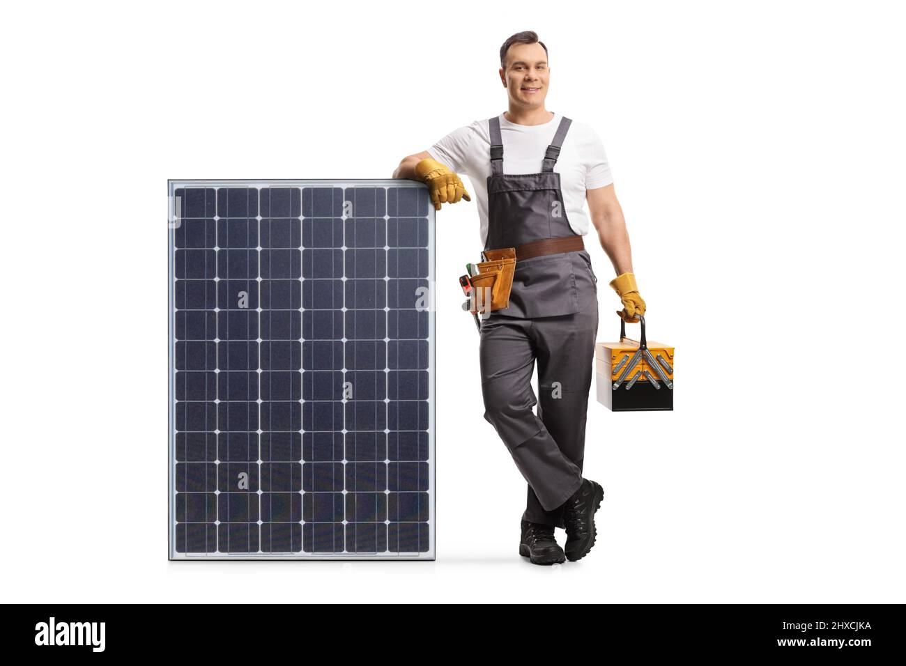 Il riparatore si appoggia su un modulo fotovoltaico per un'energia solare sostenibile isolata su sfondo bianco Foto Stock