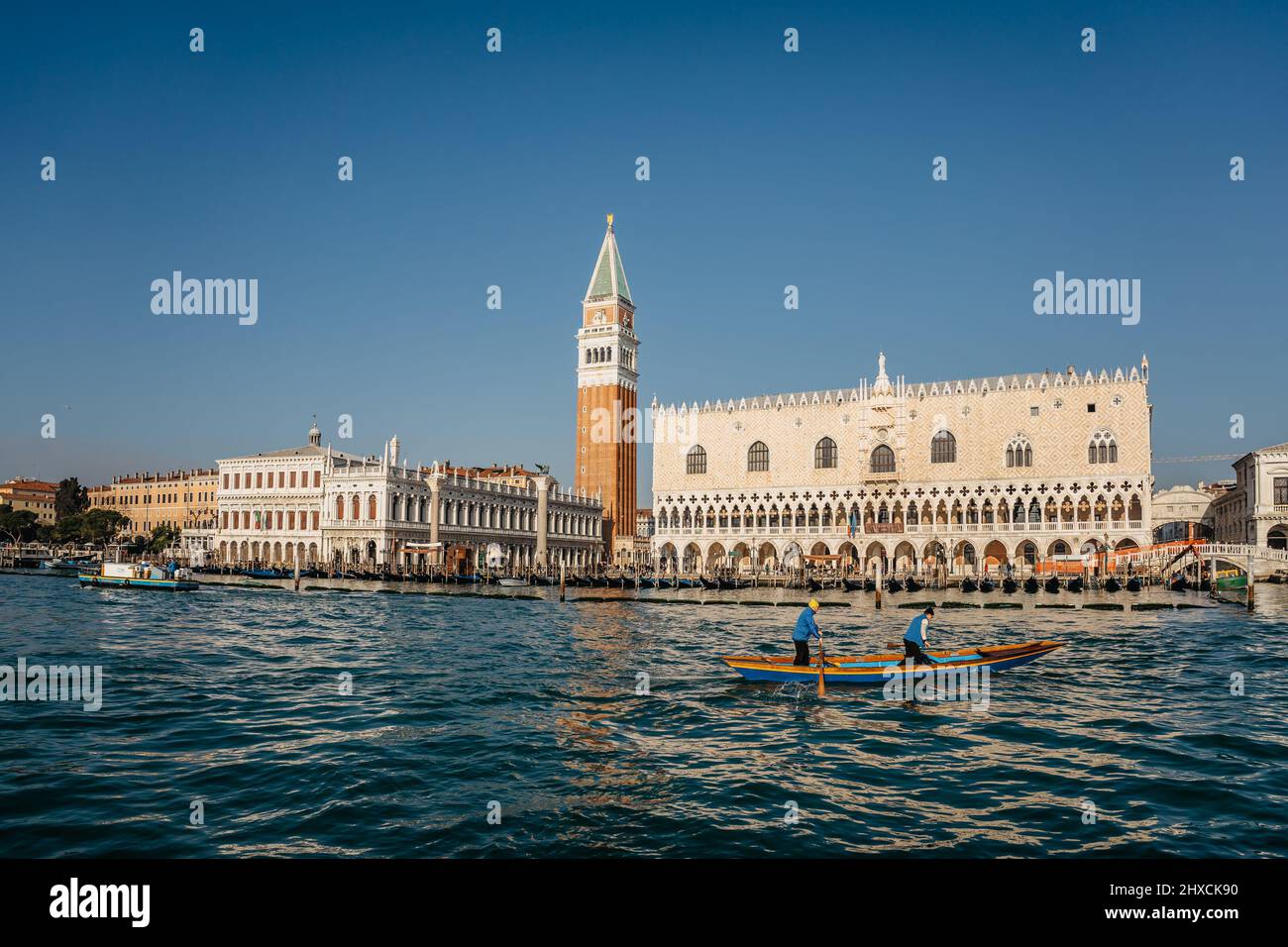 Venezia,Italia-Gennaio 29,2022. Famosa Piazza San Marco con Palazzo dei Dogi, campanile in giornata di sole, gente che paddling in barca. Mattina presto in popolare Foto Stock