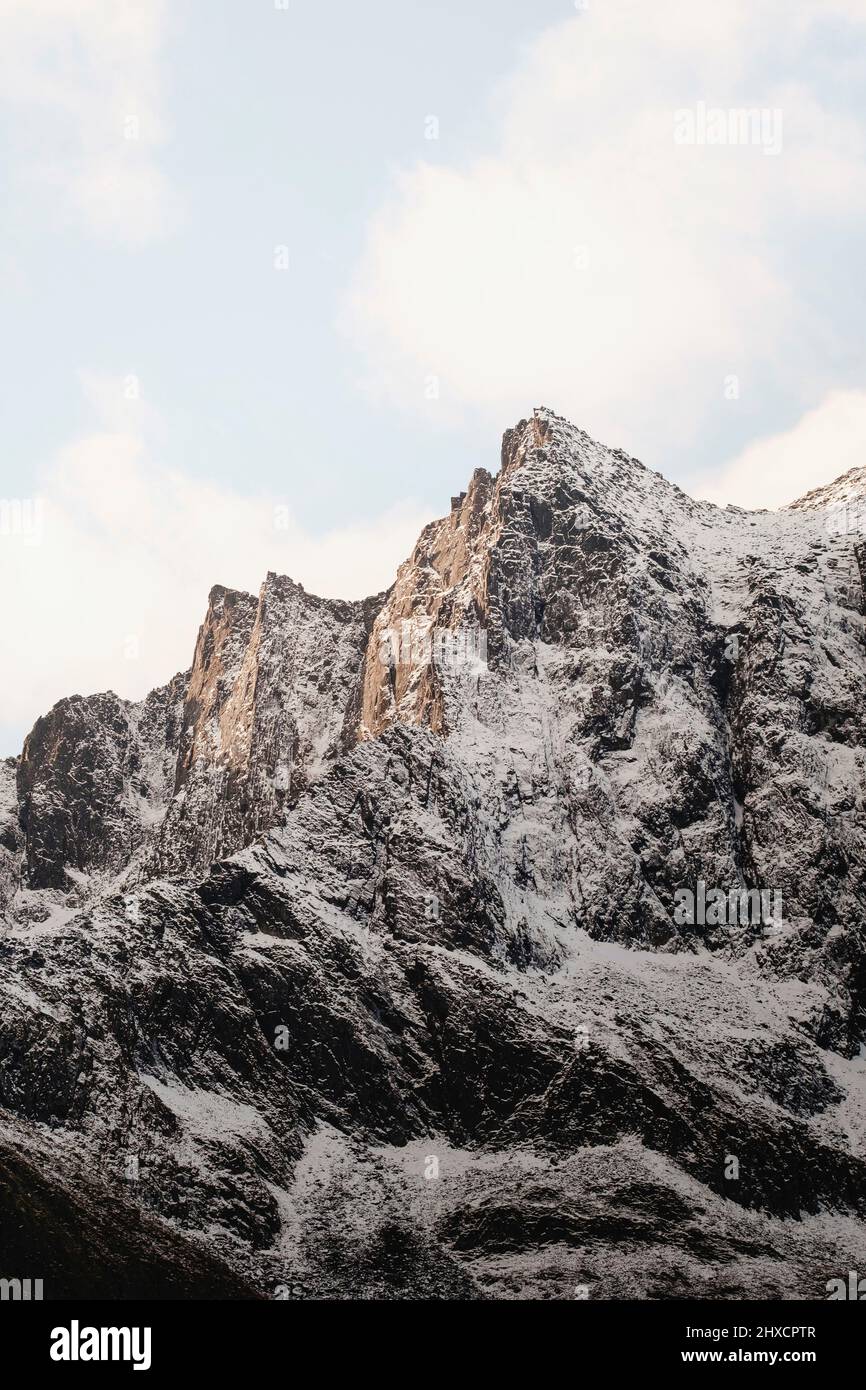 il sole colpisce le vette innevate durante il tramonto Foto Stock