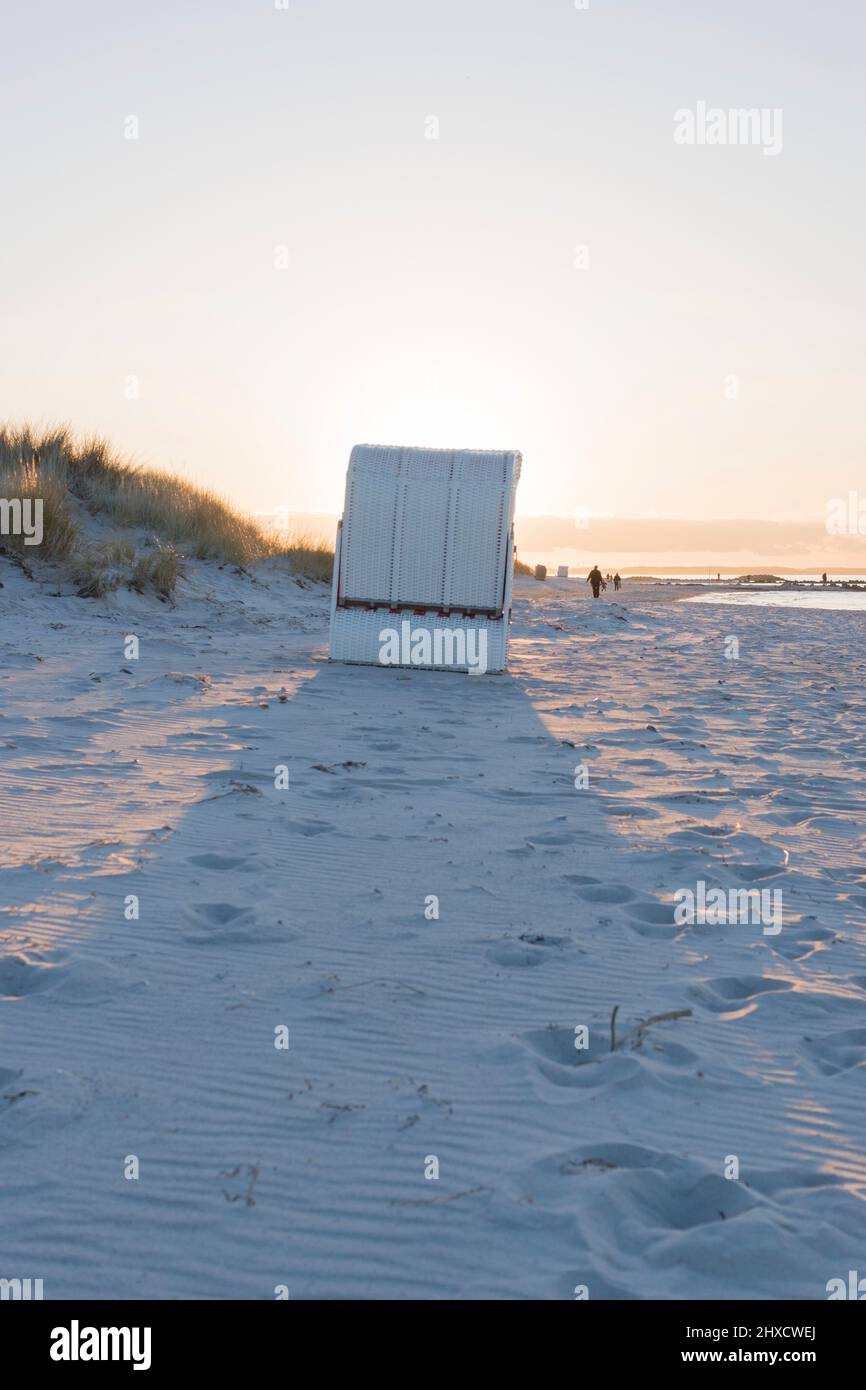 Una sedia da spiaggia nella luce del sole sulla spiaggia di Heidkate sul Mar Baltico a Wisch, Germania. Foto Stock