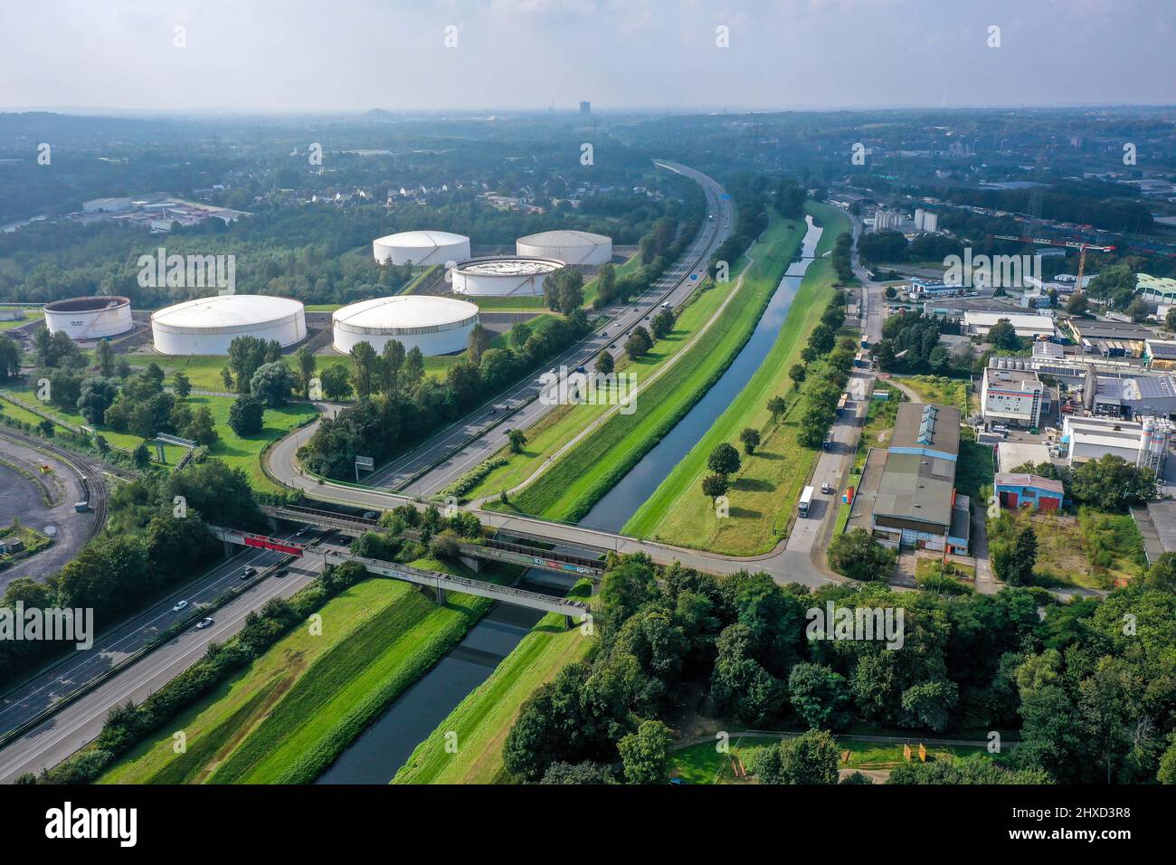 Bottrop, Renania settentrionale-Vestfalia, Germania - il fiume Emscher è completamente privo di acque reflue dal gennaio 2022 a seguito della costruzione di una rete fognaria parallela. Il fiume, qui accanto all'autostrada A42, era in precedenza una fognatura aperta e sopraindicata per le acque reflue, fognaria combinata con acque superficiali e fognarie. Sulla sinistra, fattoria serbatoio al porto di Bottrop. Foto Stock