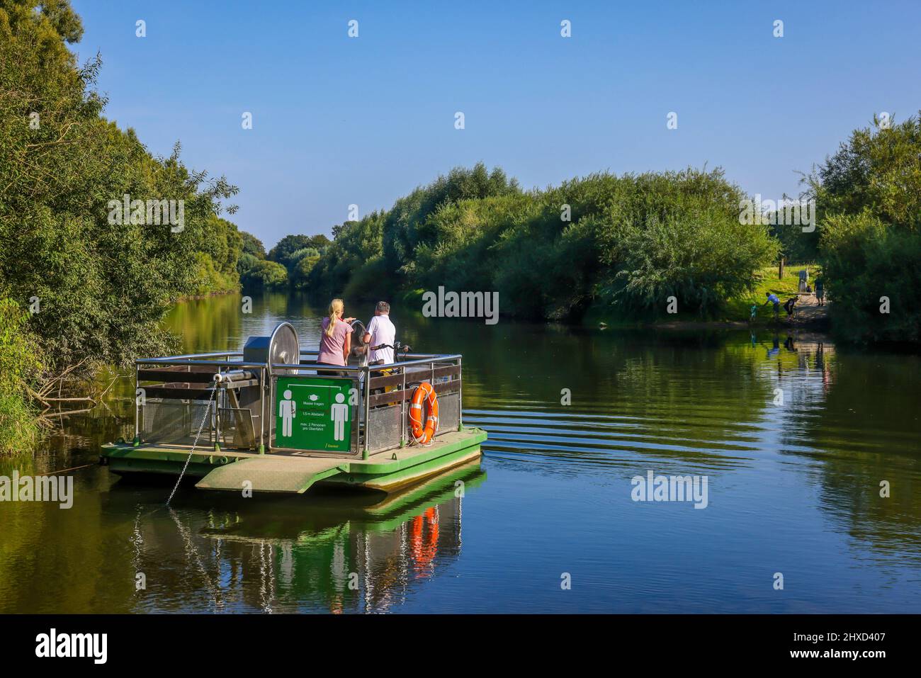 Dorsten, Renania settentrionale-Vestfalia, Germania - Lippefaehre Baldur attraversa il fiume Lippe in estate. Con gli escursionisti di potenza muscolare possono attraversare il fiume Lippe vicino a Dorsten. Il traghetto è guidato a mano. Nota: Le persone raffigurate hanno dato il loro consenso alla pubblicazione stampa. Foto Stock