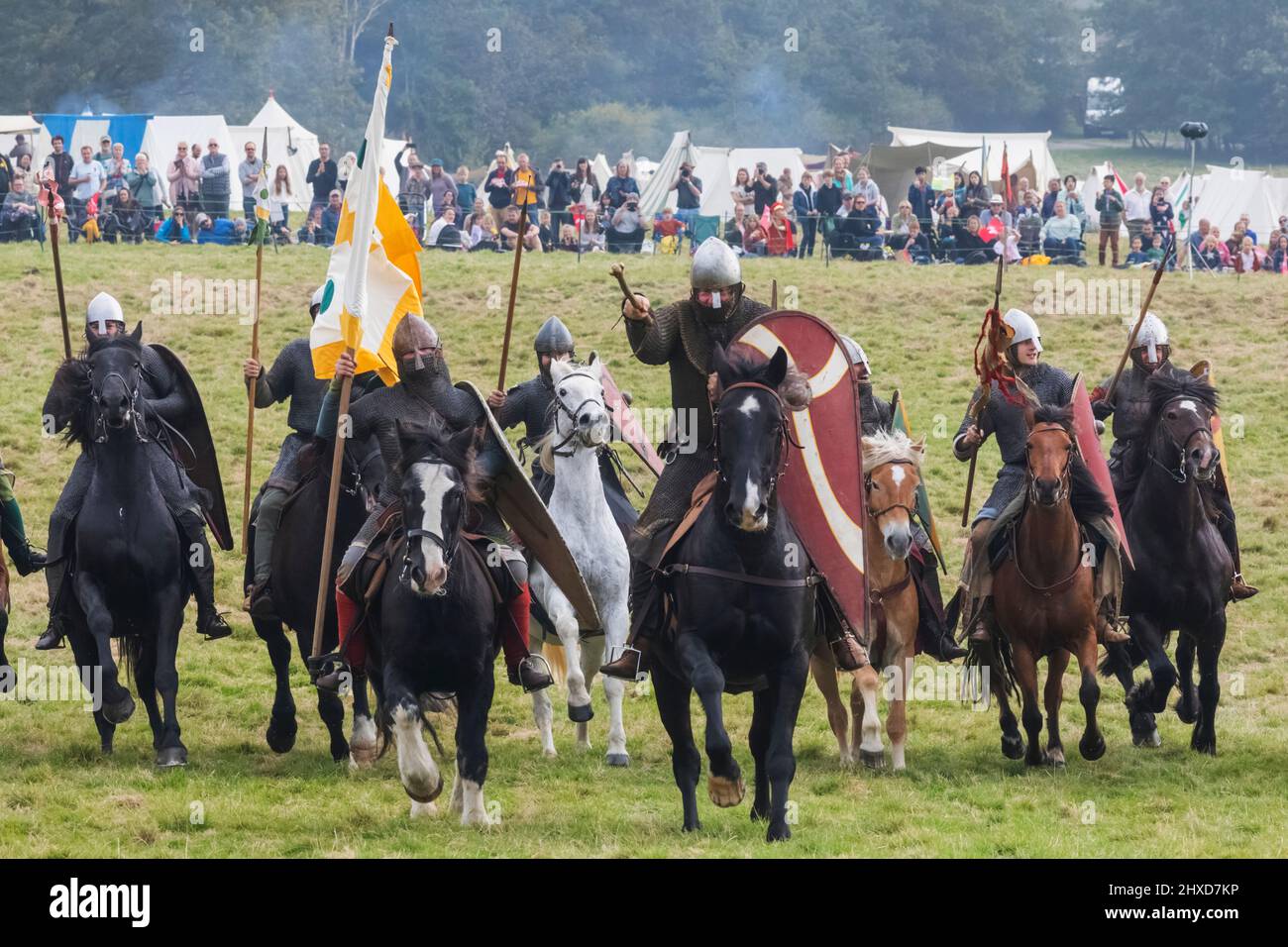 Inghilterra, East Sussex, Battle, The Annual Battle of Hastings 1066 Re-enactment Festival, partecipanti vestiti in medievale Norman Armor Charging su Horseback Foto Stock