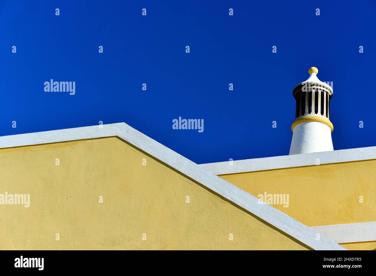 Tipica villa bianca e gialla di fronte al cielo azzurro, Luz, Algarve, Portogallo Foto Stock