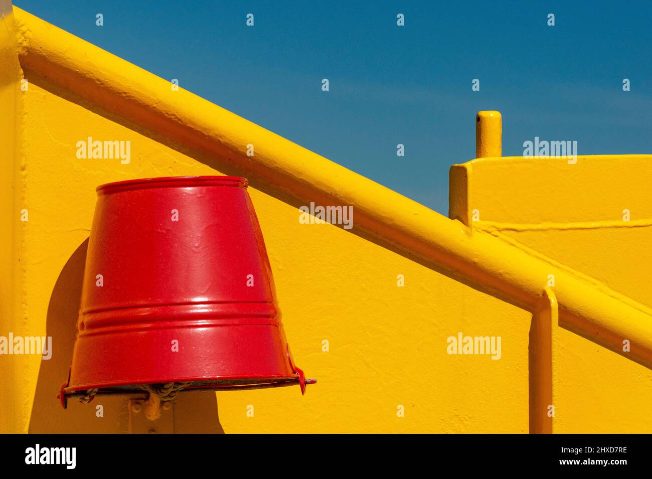 Secchio rosso sul traghetto giallo contro il cielo blu, Malö, Svezia Foto Stock