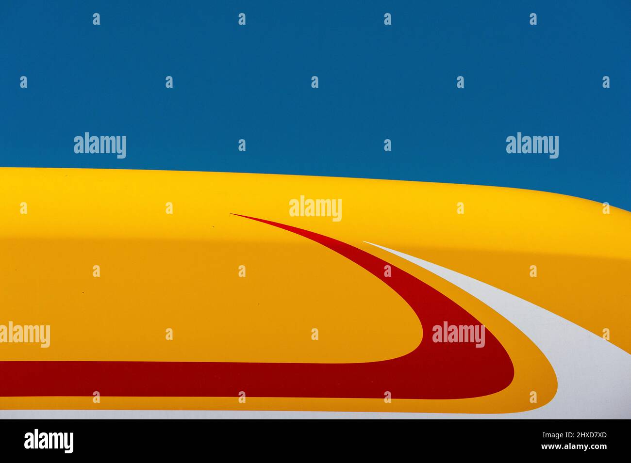 Cielo blu e tetto giallo, bianco e rosso del camion, Inghilterra Foto Stock