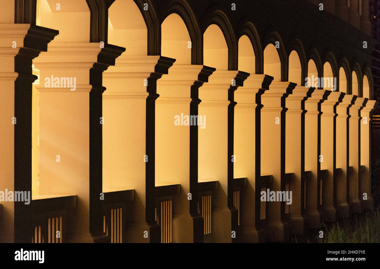 Fila illuminata di colonne al buio, Sinpagore Foto Stock