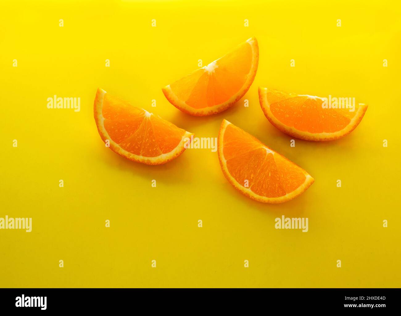 Frutta all'arancia. Fette arancioni su sfondo giallo. Frutta fresca di agrumi. Foto Stock