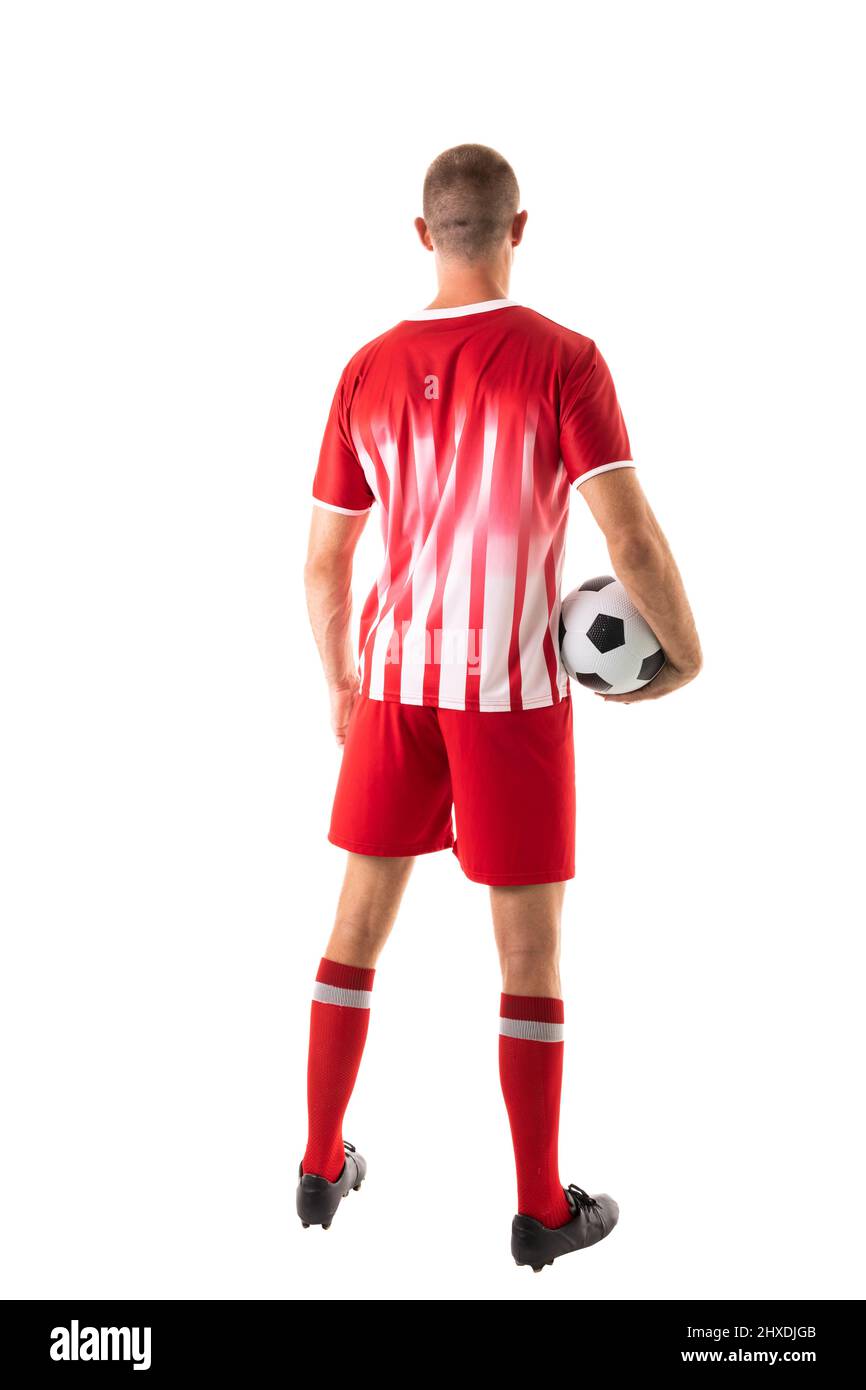 Vista posteriore a tutta lunghezza dell'atleta caucasico maschio che tiene la palla da calcio su sfondo bianco Foto Stock
