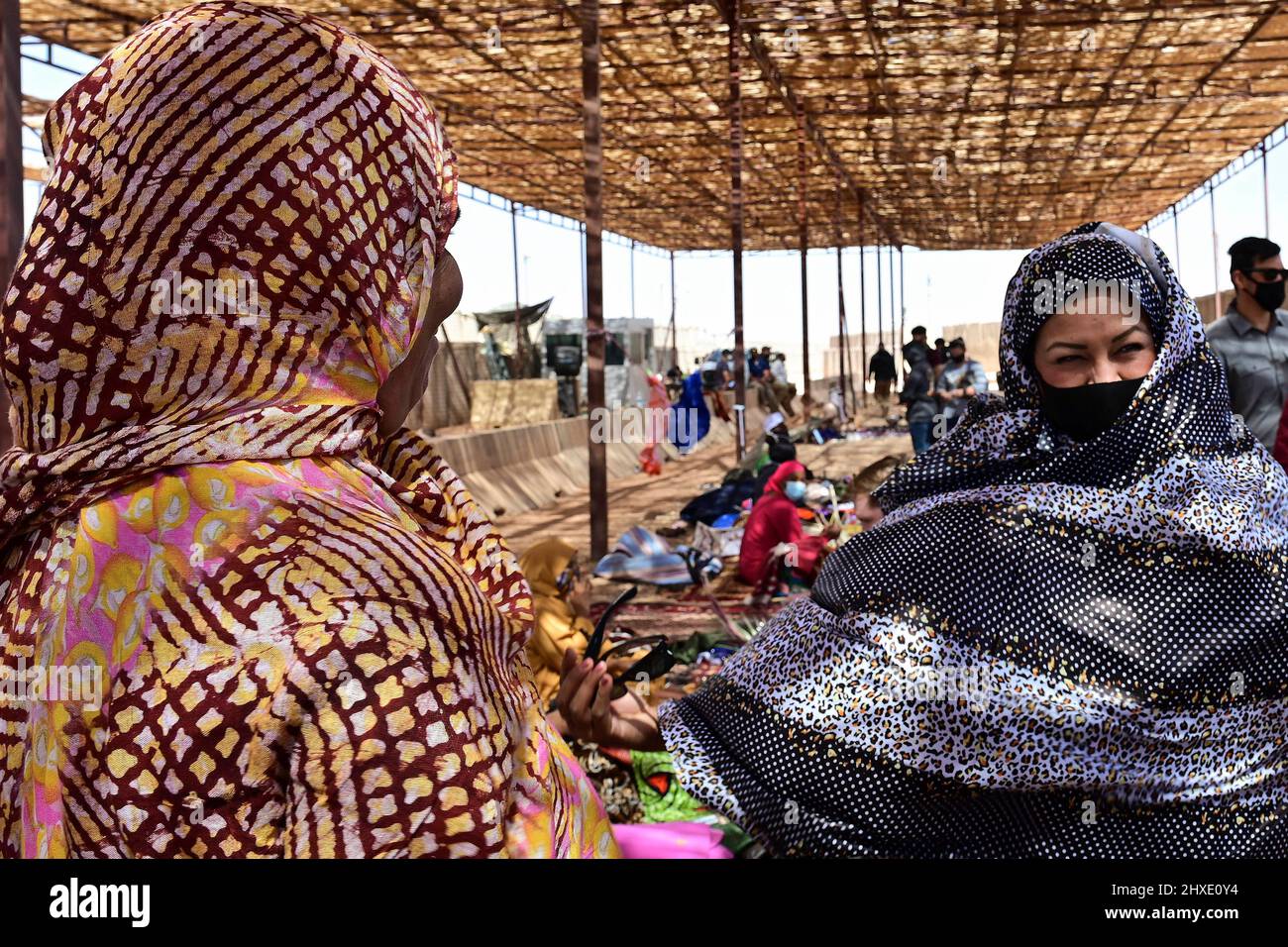 Agadez, Niger. 27th Feb 2022. Maribel Seegmiller (a destra), 724th Expeditionary Air base Squadron direttore delle operazioni, prova su un vestito africano tradizionale durante un bazar alla base aerea di Nigerien 201, Agadez, Niger, 27 febbraio 2022. Oltre 40 venditori locali dalla città di Agadez e villaggi circostanti frequentavano il bazar, vendendo vari prodotti. I membri del servizio statunitense hanno acquistato circa 10.532.000 franchi CFA dell'Africa occidentale (18K dollari USA) di merce. Eventi come questi migliorano le relazioni tra Stati Uniti e Niger e stimolano lo sviluppo economico locale. (Credit Image: © U.S. Foto Stock
