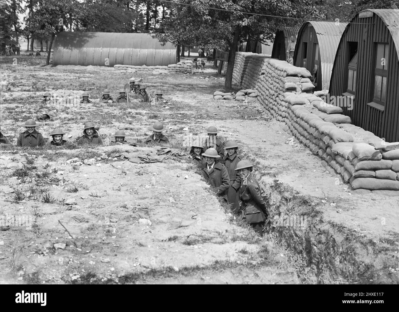 I membri del corpo ausiliario dell'esercito della Regina Maria indossano caschi d'acciaio mentre in trincee costruite per ripararsi in caso di attacco aereo a Rouen, Francia, il 18 giugno 1918. Foto Stock