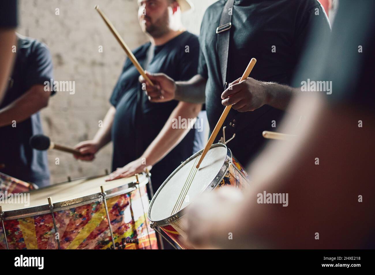 Potete sentire il battito. Primo piano di un musicista che suona la batteria con la sua band. Foto Stock