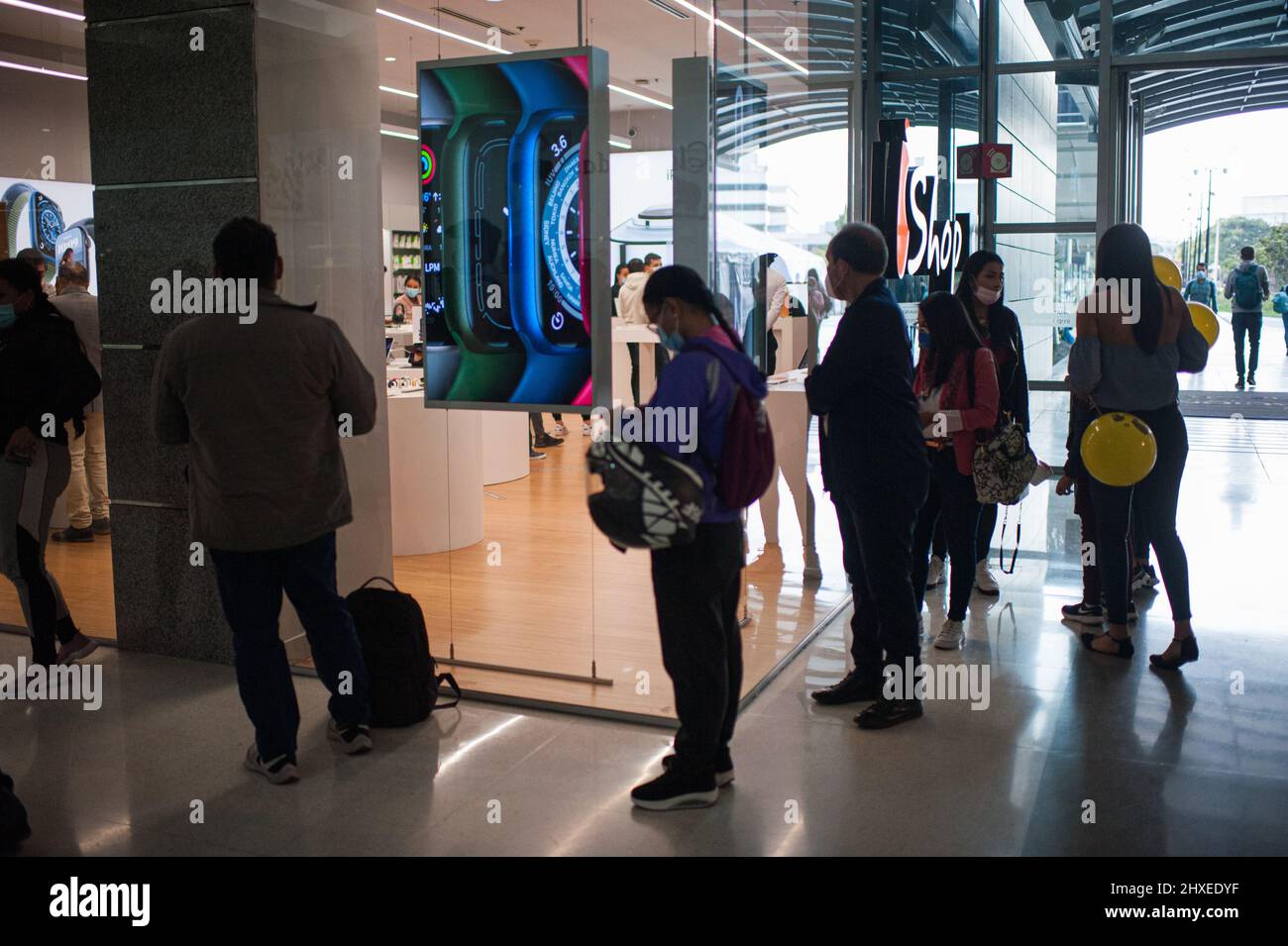 Le persone aspettano fuori da un rivenditore Apple Store mentre le persone in tutta la Colombia approfittano del primo giorno senza IVA del 2022 per acquistare vestiti ed elettronica senza una tassa del 19% su prodotti selezionati, a Bogota, Colombia, il 11 marzo 2022. Foto Stock