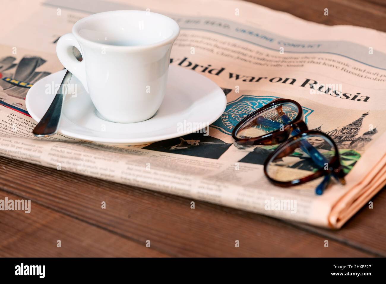 Giornali e una tazza di caffè con la prima GUERRA SULLA RUSSIA al tavolo al chiuso Foto Stock