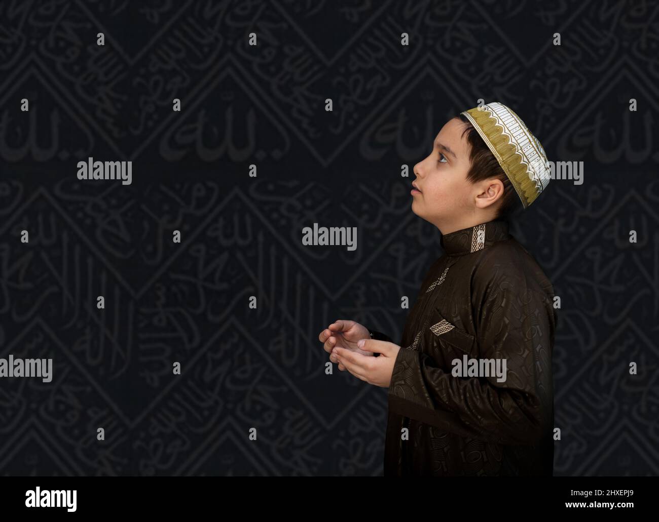 Bambino musulmano in abiti bianchi tradizionali, pregando a Kaaba in Makkah. Foto di alta qualità Foto Stock