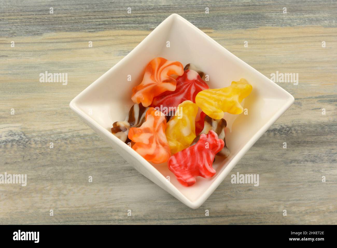 Caramelle alla frutta a forma di mucche in un piatto di caramelle bianche Foto Stock