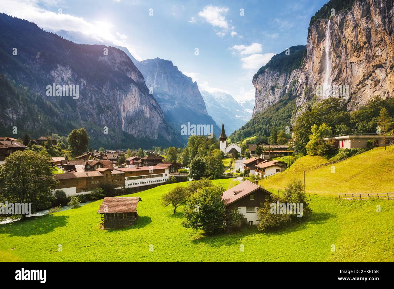 Vista maestosa del villaggio alpino che brilla dalla luce del sole. Scena pittoresca e splendida. Ubicazione luogo famoso Alpi svizzere, valle Lauterbrunnen, Staubbach Foto Stock