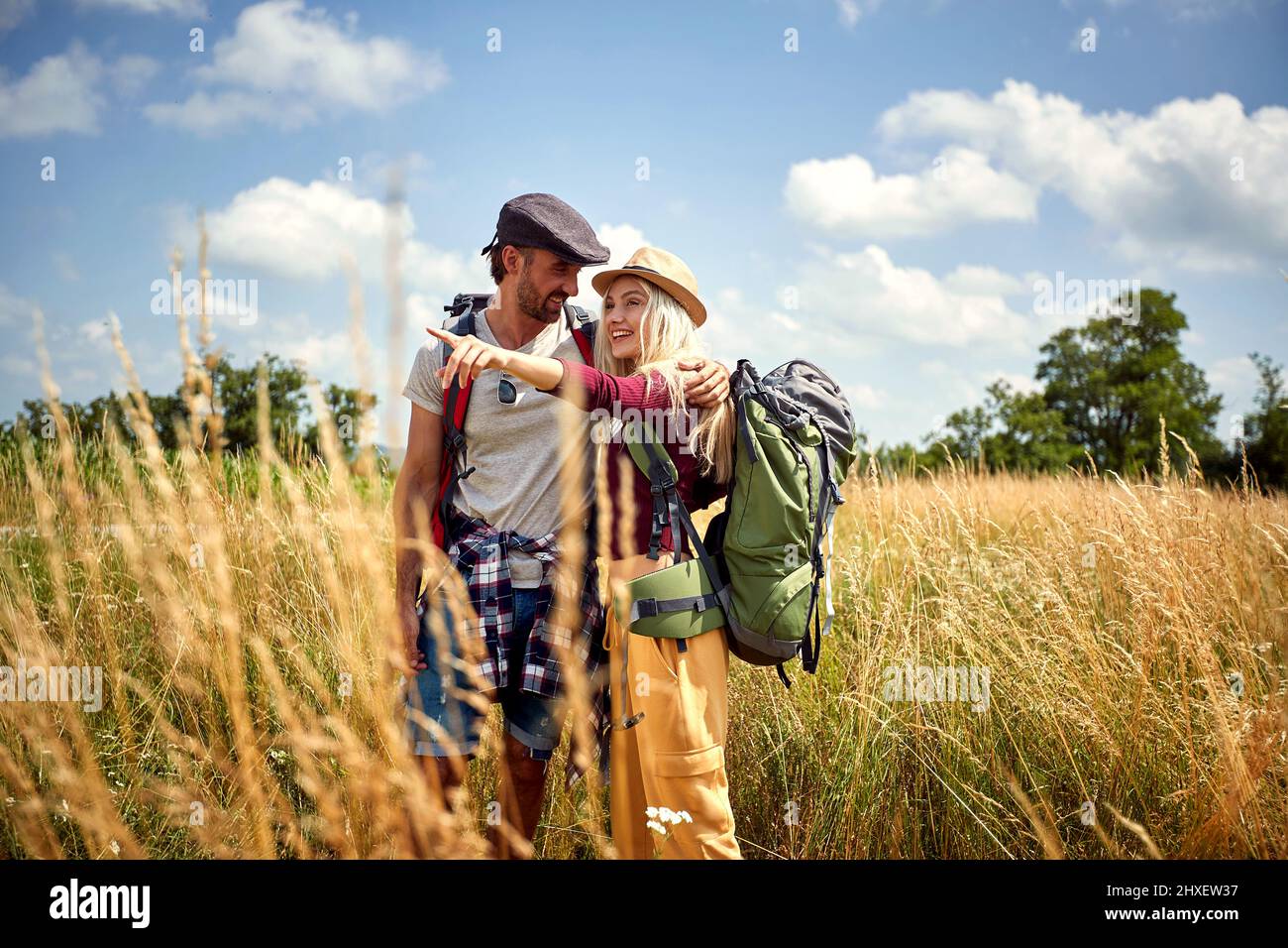 Giovane coppia escursioni con zaino in campo. Sport, libertà, concetto di vacanza. Foto Stock