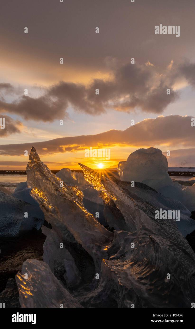il sole splende attraverso il ghiaccio a Diamond Beach, Breidamerkursandur, Islanda sud-orientale Foto Stock