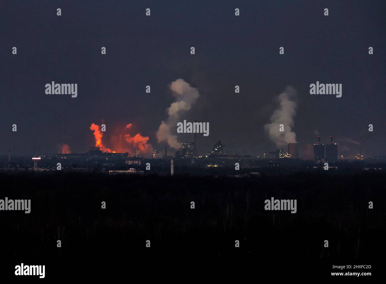 HKM, le opere metallurgiche di Krupp Mannesmann GmbH, si illuminano di rosso attraverso la maschiatura dell'acciaio Foto Stock