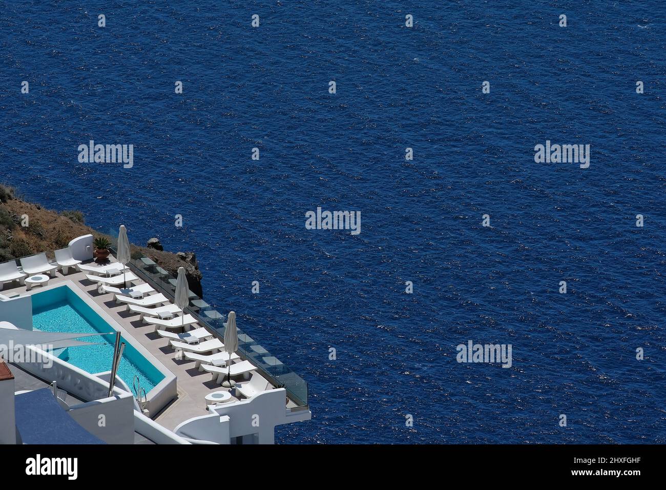 Vista spettacolare sulla caldera e sul vulcano di Santorini da un hotel di lusso con lettini Foto Stock