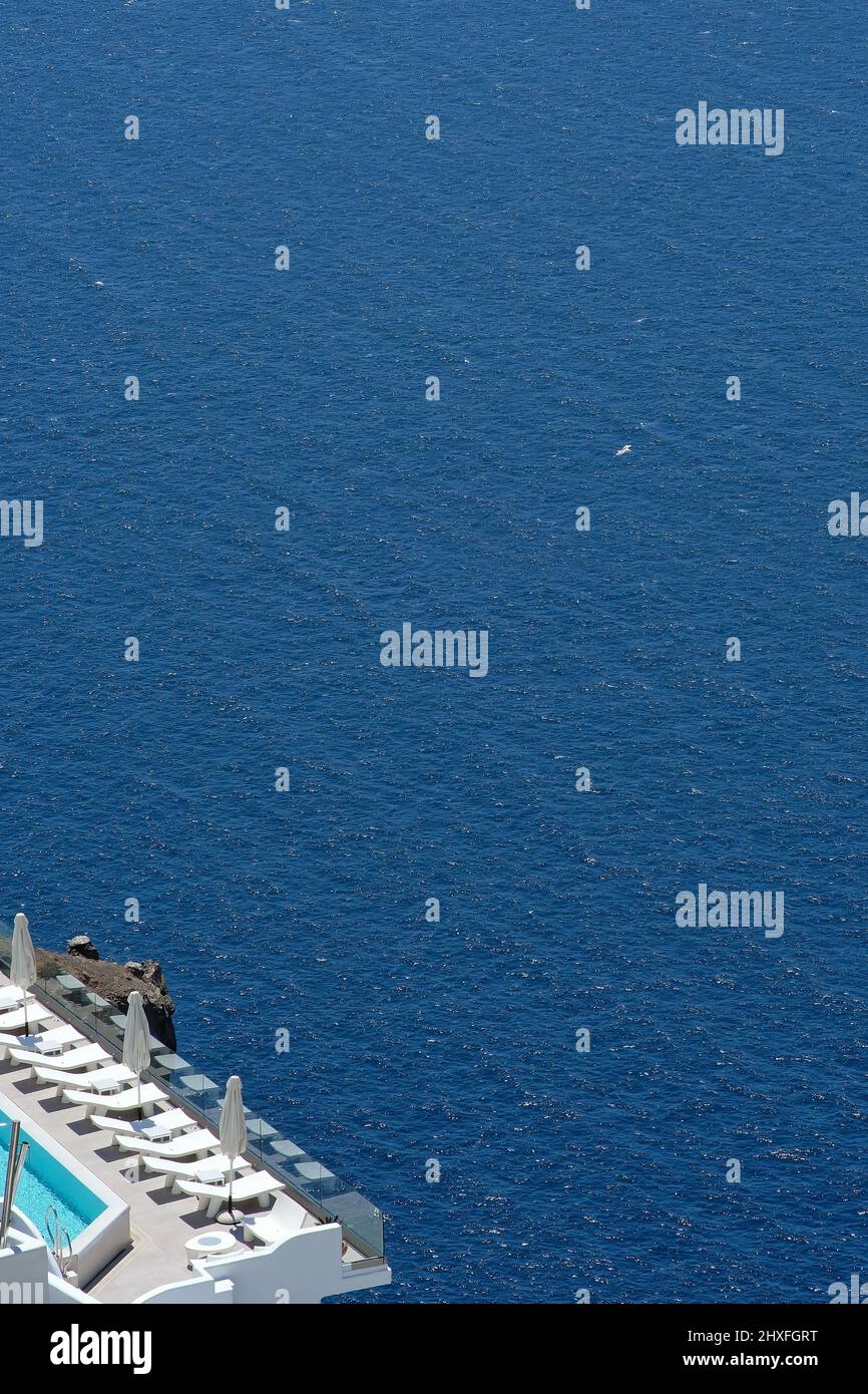 Vista spettacolare sulla caldera e sul vulcano di Santorini da un hotel di lusso con lettini Foto Stock
