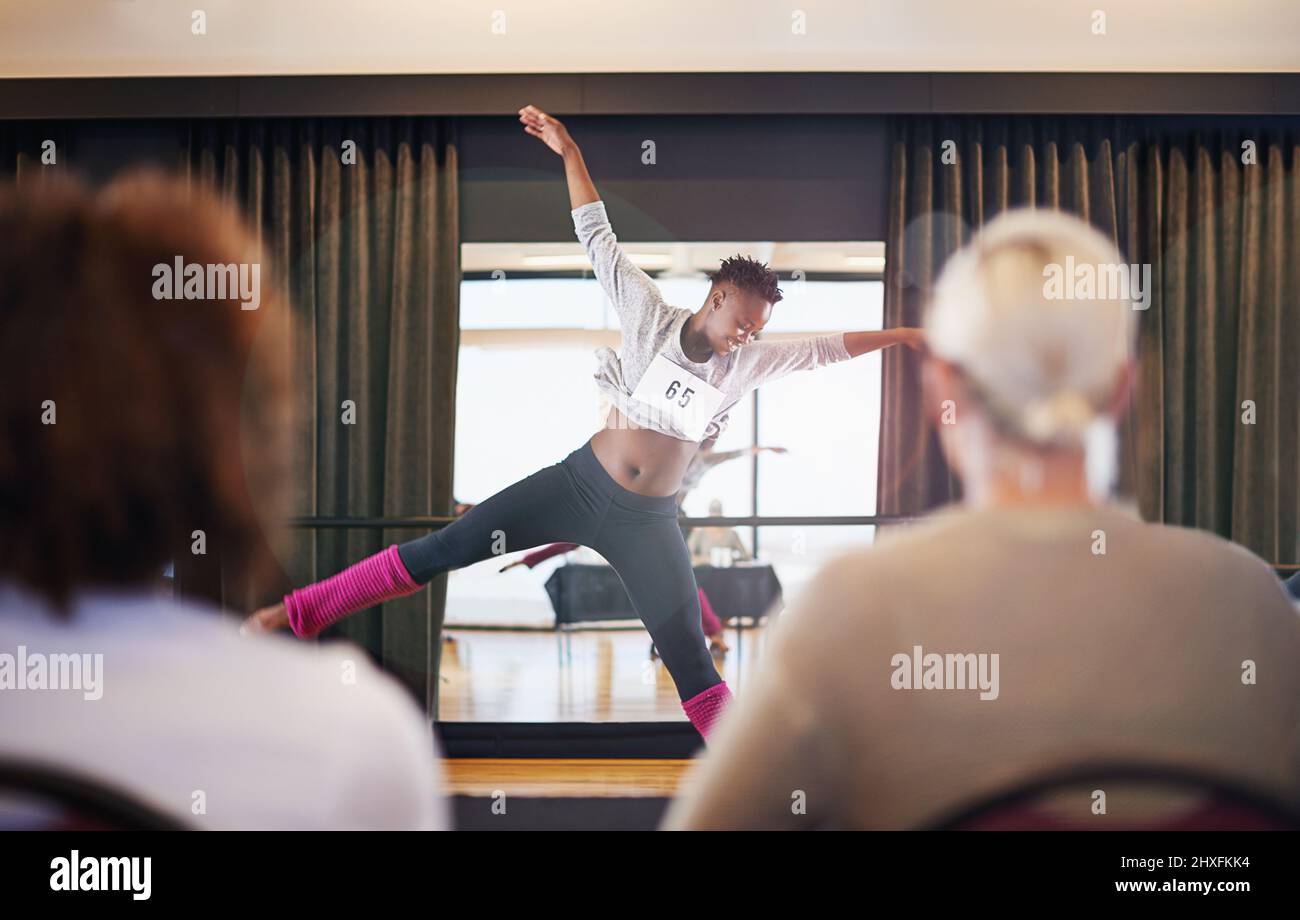 Passare alla musica. Shot di una ballerina femminile che si esibisce davanti ai giudici durante un'audizione di danza. Foto Stock