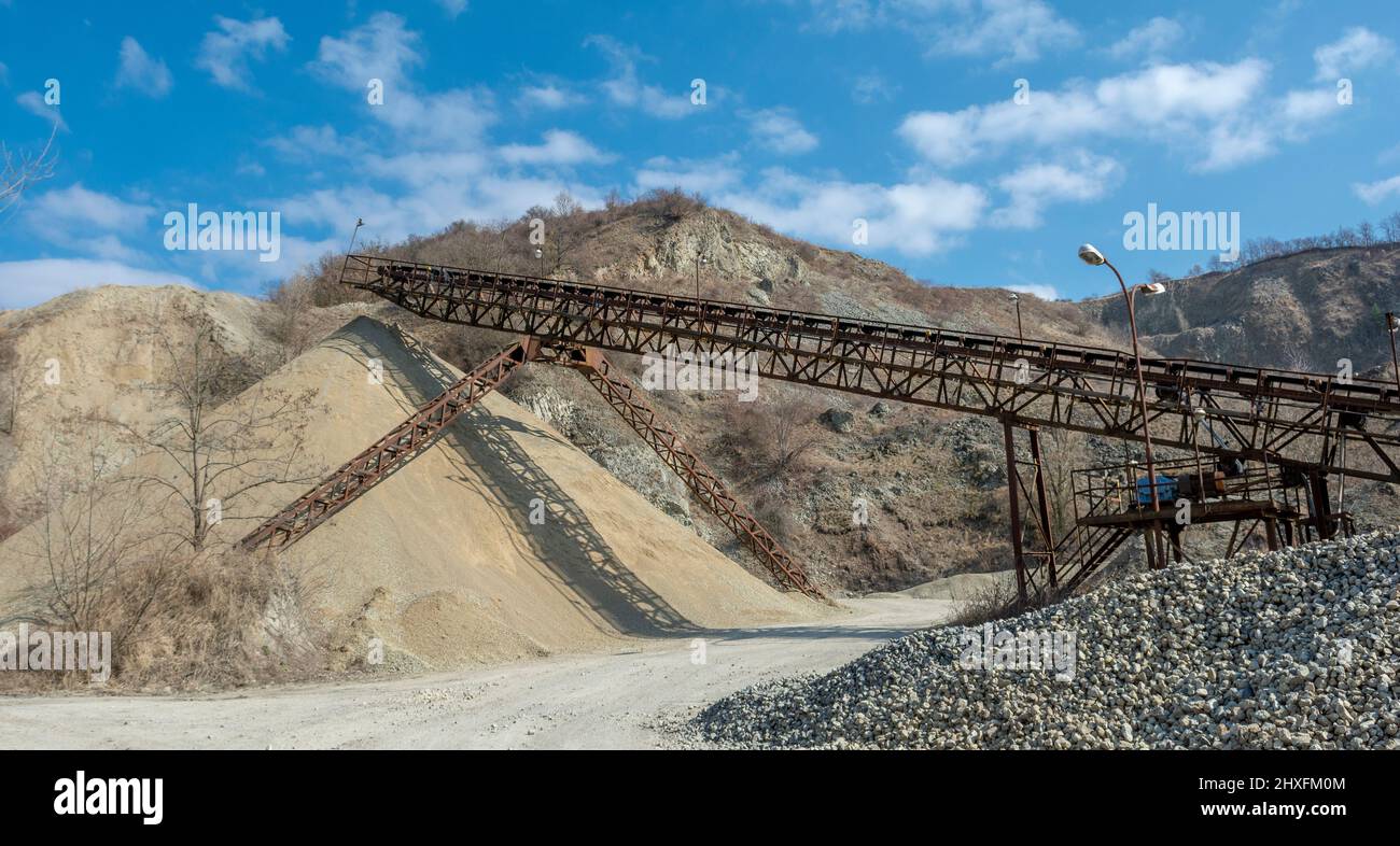 Nastro trasportatore in una vecchia cava di ghiaia. Attrezzature per estrazione mineraria e cava. Foto Stock