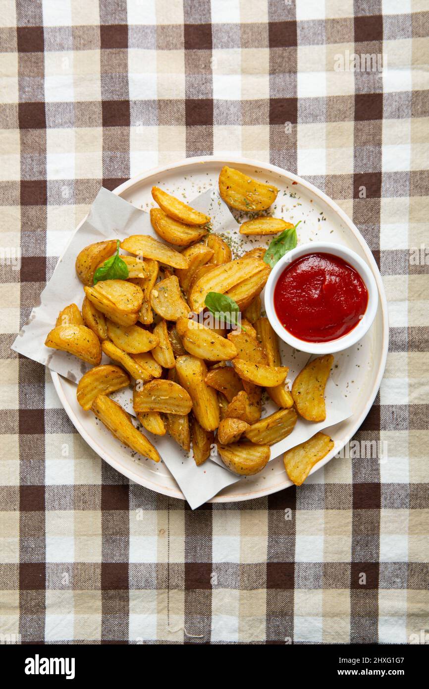 Vista dall'alto dei cunei di patate e del ketchup sul piatto Foto Stock