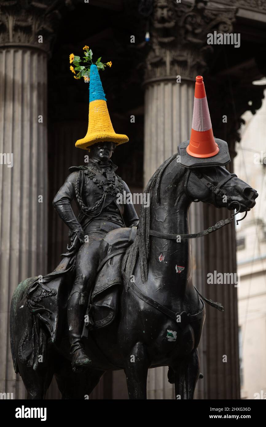 Glasgow, Regno Unito, 12th marzo 2022. Statua del Duca di Wellington in Queen Street con un cappello a cono di polizia a tema bandiera Ucraina blu e giallo, come accovacciato da Pauline McWhirter, a sostegno dell'Ucraina nella loro attuale guerra con il Presidente PutinÕs Russia, a Glasgow, Scozia, 12 marzo 2022. Photo credit: Jeremy Sutton-Hibbert/Alamy Live News. Foto Stock
