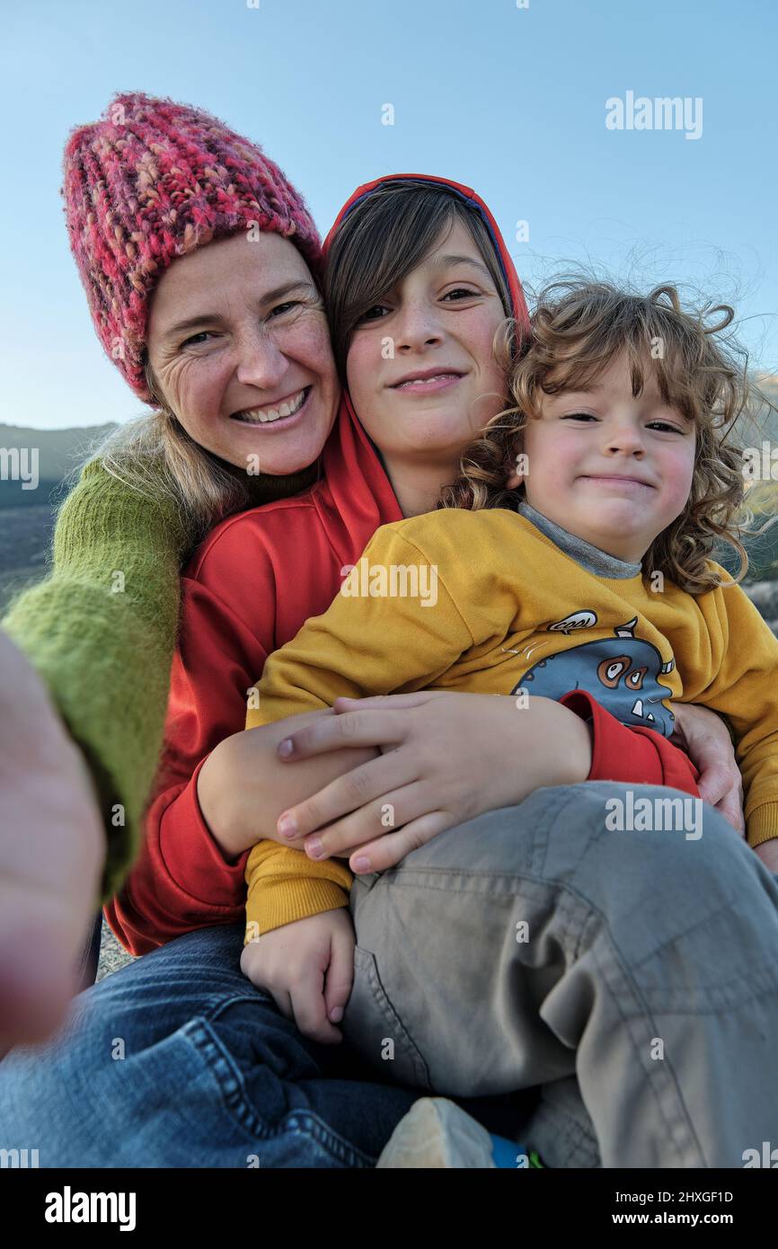 Una madre felice che fa un selfie con i suoi figli in natura Foto Stock