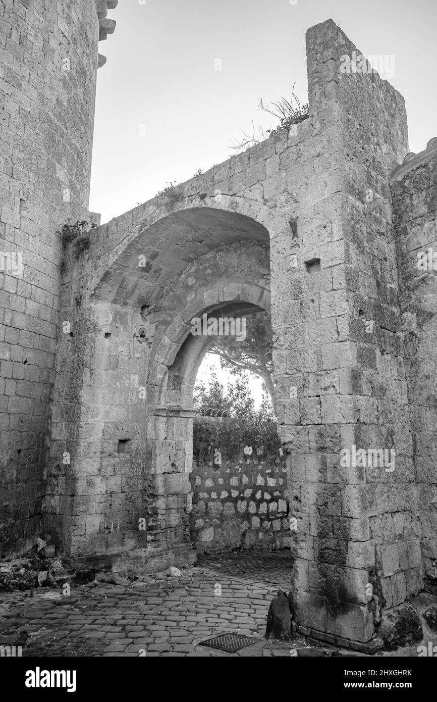 Il borgo di Tarquinia, Viterbo, Lazio, Italia - porta di Castello, l'arco di accesso attraverso le antiche mura difensive della città, con la grande c Foto Stock