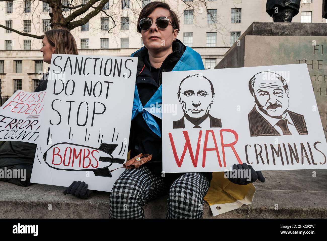 Londra UK, 12th marzo 2022. Cittadini e sostenitori ucraini continuano a radunarsi a Whitehall di fronte a Downing Street e chiedono ulteriori azioni contro la Russia per l'invasione dell'Ucraina da parte della comunità internazionale. Il manifestante ha un cartello che accusa il presidente Vladimir Putin e il ministro degli Esteri Sergei Lavrov di crimini di guerra. Foto Stock
