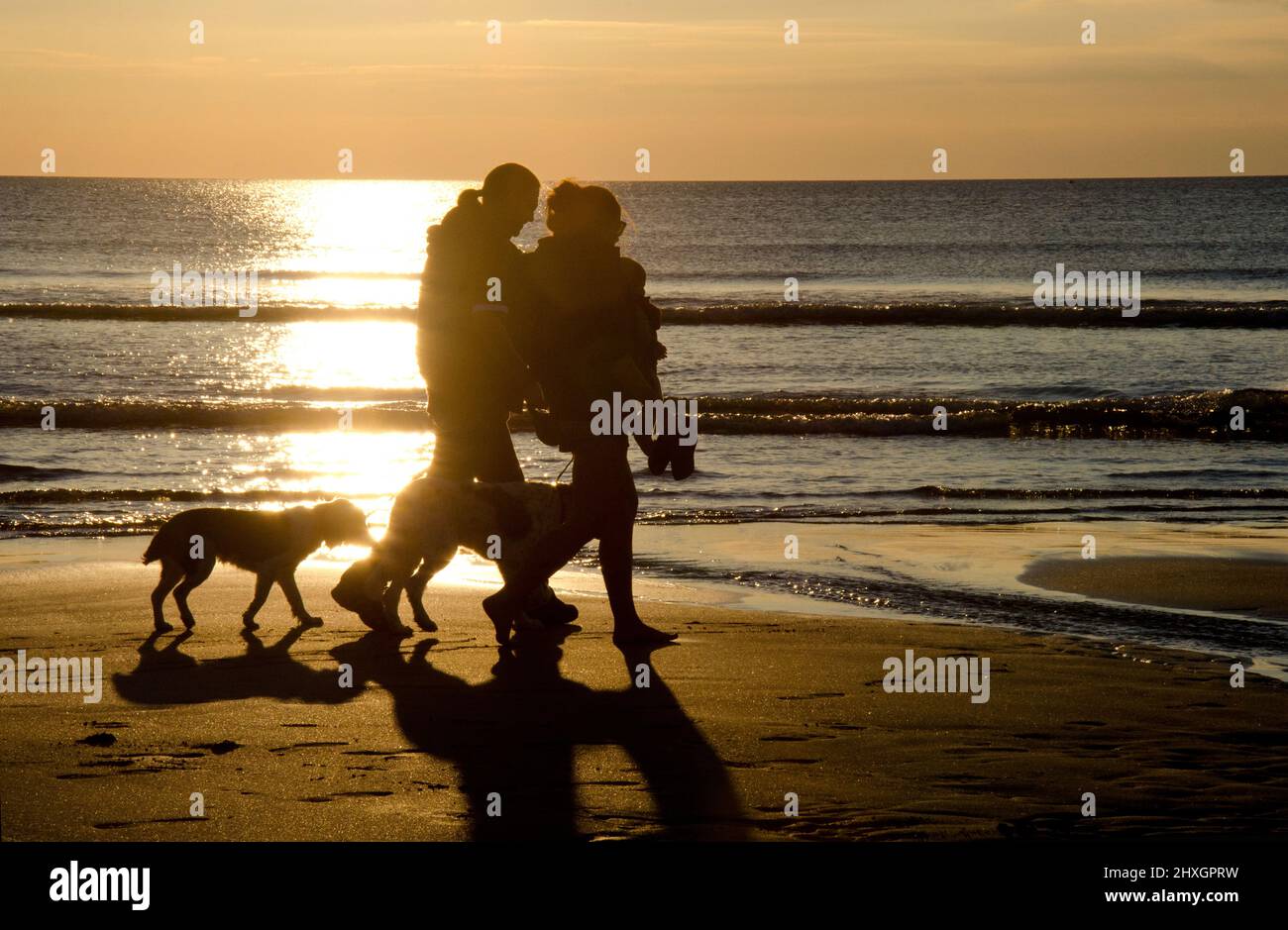 Tramonto a piedi sulla spiaggia Foto Stock