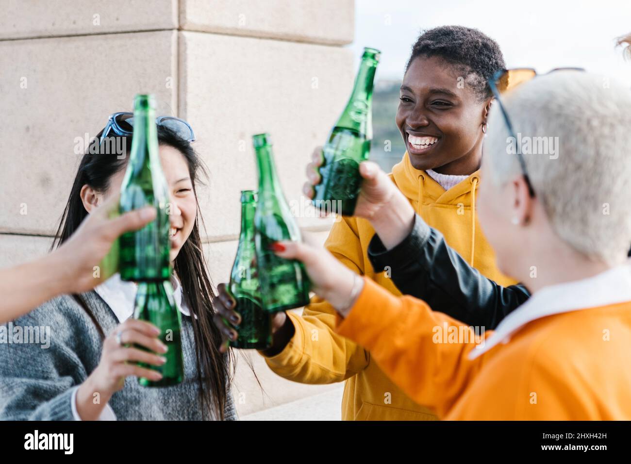 Amici felici e millenari che bevono insieme all'aperto Foto Stock