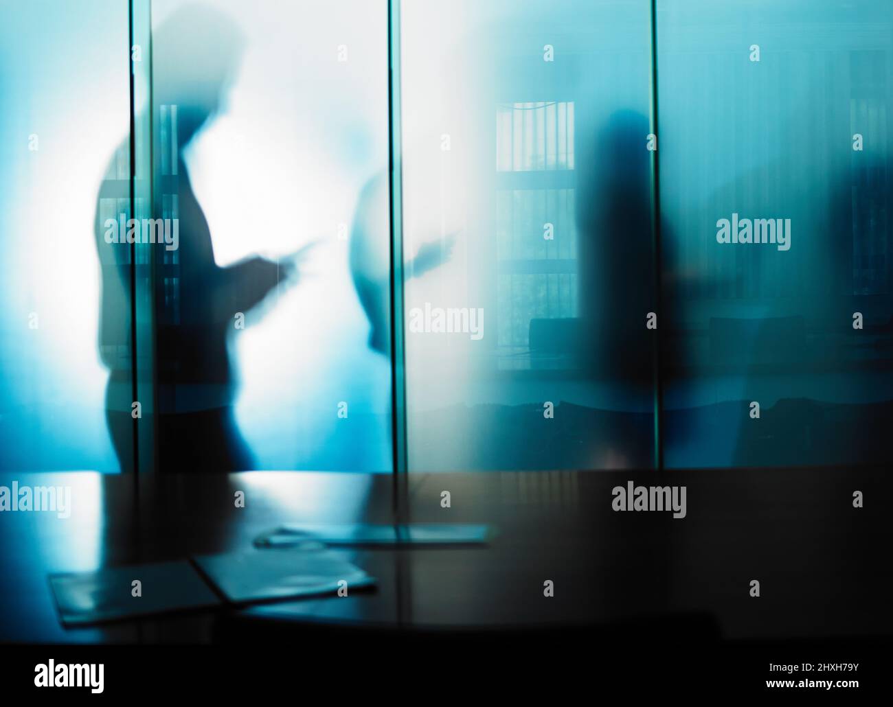 Il lavoro invisibile è spesso il più importante. Scatto corto di una silhouette irriconoscibile degli uomini d'affari contro una parete di vetro nel suo ufficio. Foto Stock