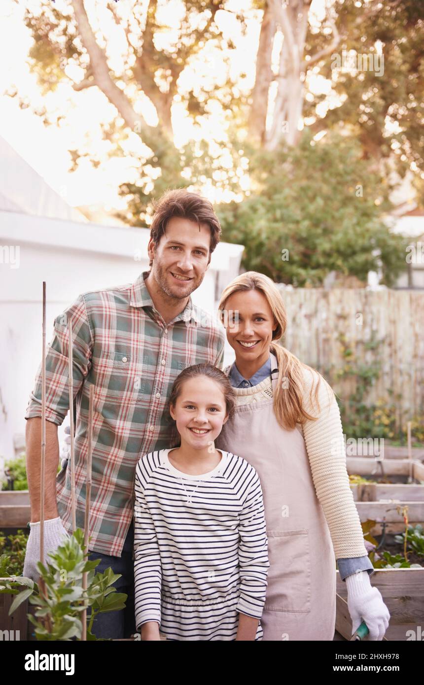 Tutta la nostra famiglia è stata organica. Ritratto di una famiglia felice giardinaggio insieme nel loro cortile. Foto Stock