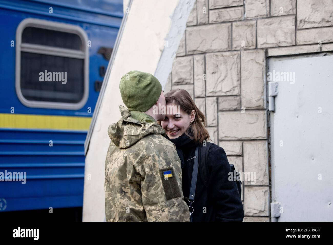 Lviv, Ucraina. 12th Mar 2022. Un soldato ha visto baciare il suo partner al binario della stazione ferroviaria di Lviv. Lviv, la più grande città dell'Ucraina occidentale, è ora diventata un centro di transito per donne e bambini in fuga verso l'Europa, mentre gli uomini ritornano e si recano nell'Ucraina orientale per difendere il paese. (Foto di Hesther ng/SOPA Images/Sipa USA) Credit: Sipa USA/Alamy Live News Foto Stock