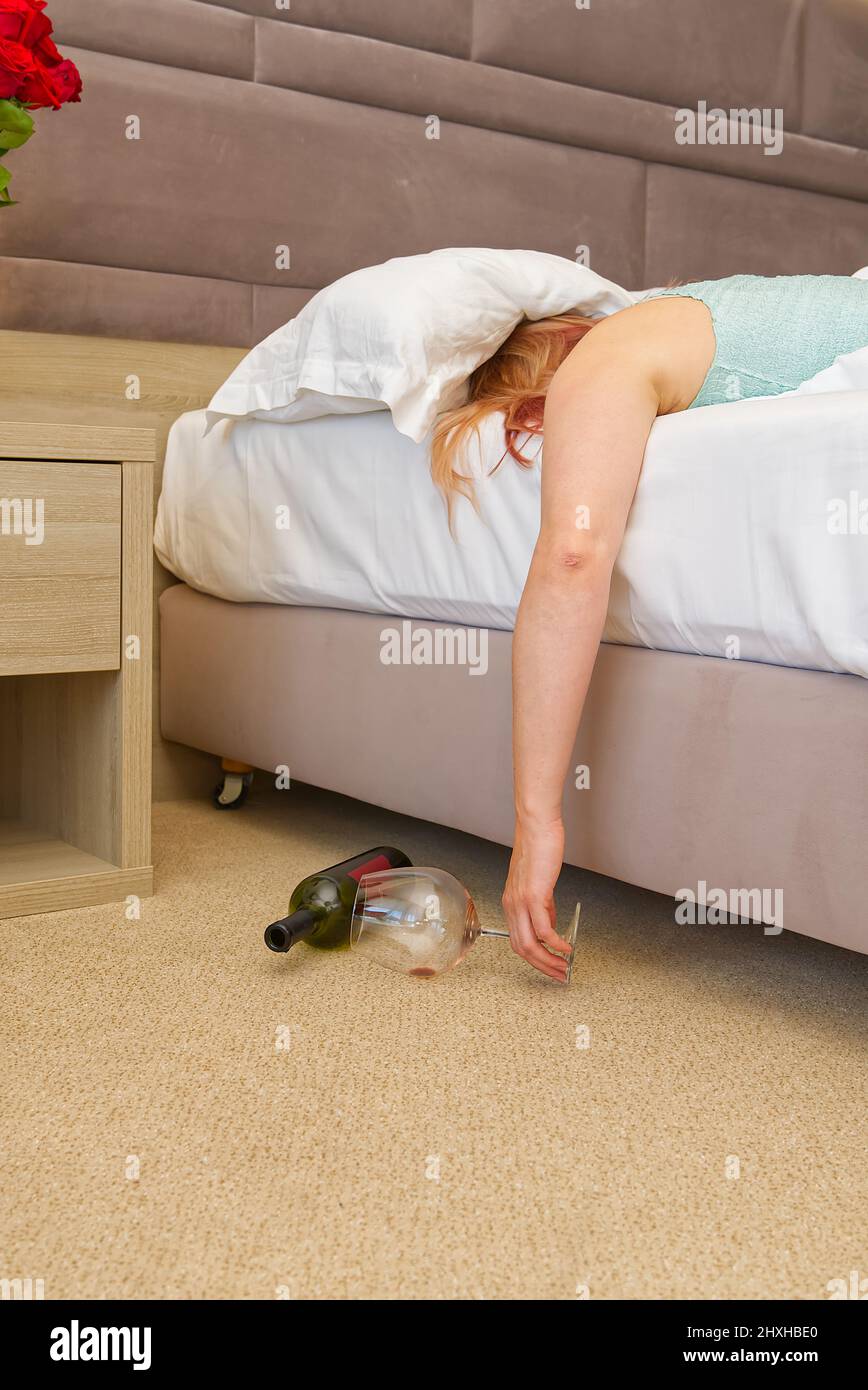 donna ubriaca si addormentò a letto. concetto di alcolismo femminile. Foto Stock