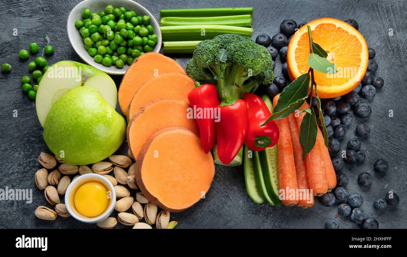 Alimenti alti in luteina su sfondo scuro. Cibo per occhi sani. Alto in antiossidanti, minerali e vitamine. Vista dall'alto, piatto Foto Stock