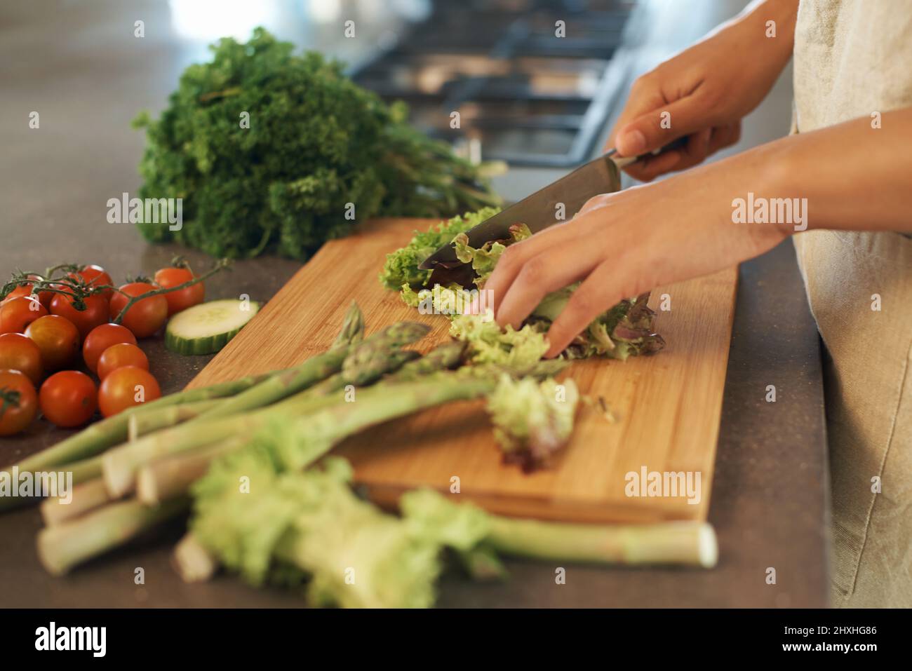 Fresco dalla terra. Shot di una donna che taglia le verdure su un tagliando assi. Foto Stock Fresco dalla terra. Shot di una donna che taglia le verdure su un tagliando assi. Foto Stock