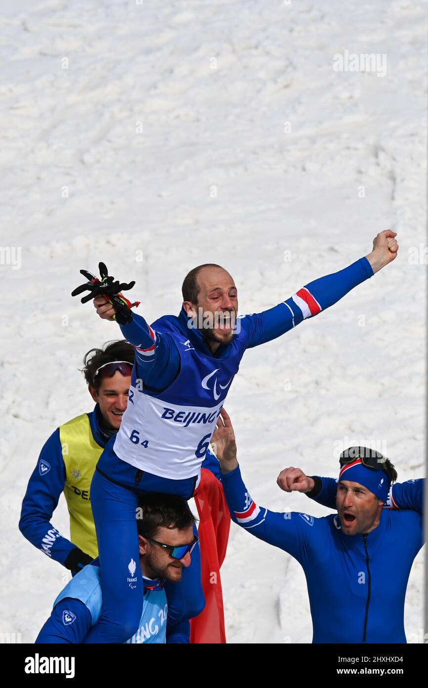 Zhangjiakou, la provincia cinese di Hebei. 13th Mar 2022. Anthony Chalencon (TOP) di Francia festeggia con i compagni di squadra dopo il Para Cross-Country Sci Open 4x2.5km relè di Pechino 2022 Paralimpiadi invernali al National Biathlon Centre di Zhangjiakou, provincia di Hebei della Cina settentrionale, 13 marzo 2022. Credit: Li Bo/Xinhua/Alamy Live News Foto Stock