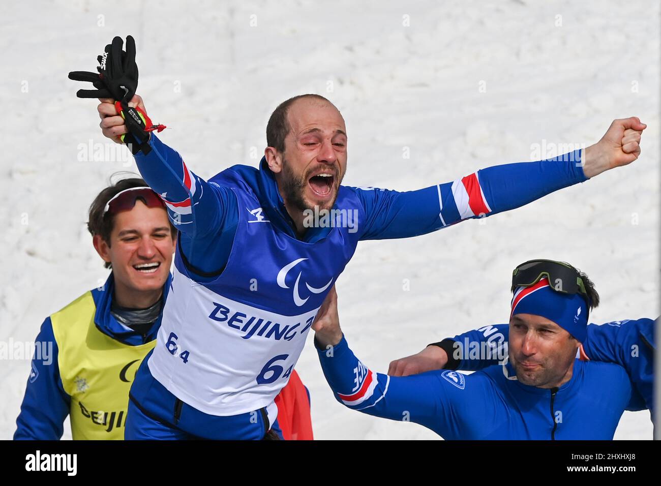 Zhangjiakou, la provincia cinese di Hebei. 13th Mar 2022. Anthony Chalencon (TOP) di Francia festeggia con i compagni di squadra dopo il Para Cross-Country Sci Open 4x2.5km relè di Pechino 2022 Paralimpiadi invernali al National Biathlon Centre di Zhangjiakou, provincia di Hebei della Cina settentrionale, 13 marzo 2022. Credit: Li Bo/Xinhua/Alamy Live News Foto Stock