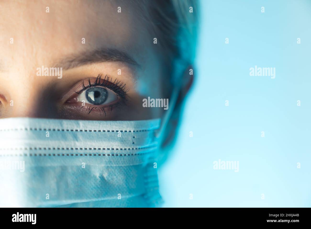 Foto ritratto da vicino. Occhio di giovane dottore femminile. Protezione contro le malattie contagiose attraverso indossare maschera medica chirurgica igienica viso. Foto di alta qualità Foto Stock