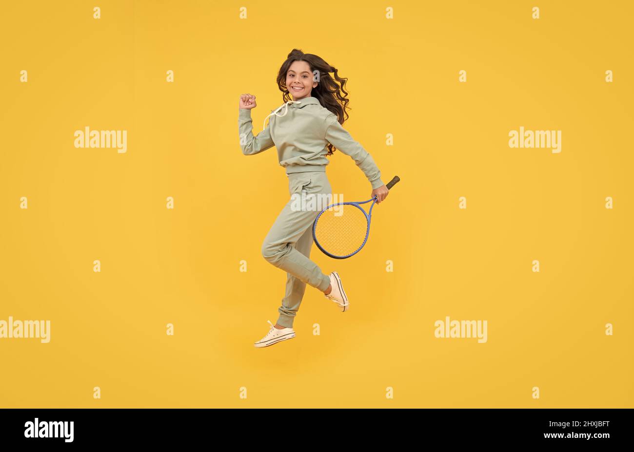 happy energico bambino salto in abbigliamento sportivo con racchetta squash running al successo, stamina. Foto Stock